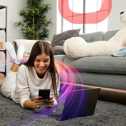 Mujer usando una computadora portátil y un teléfono móvil en casa